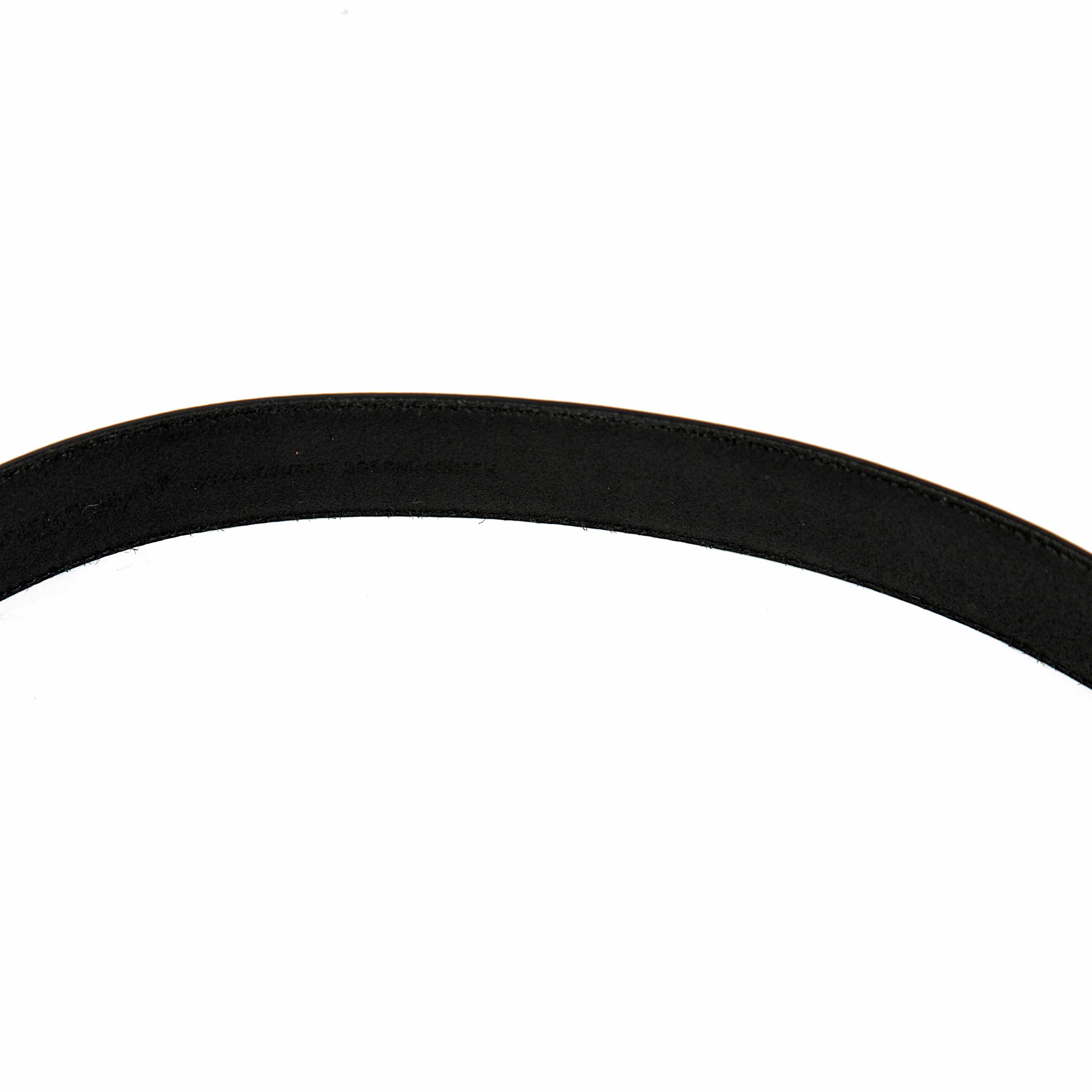 This sophisticated belt offers a unique twist on classic design with its distinctive dual-buckle system.