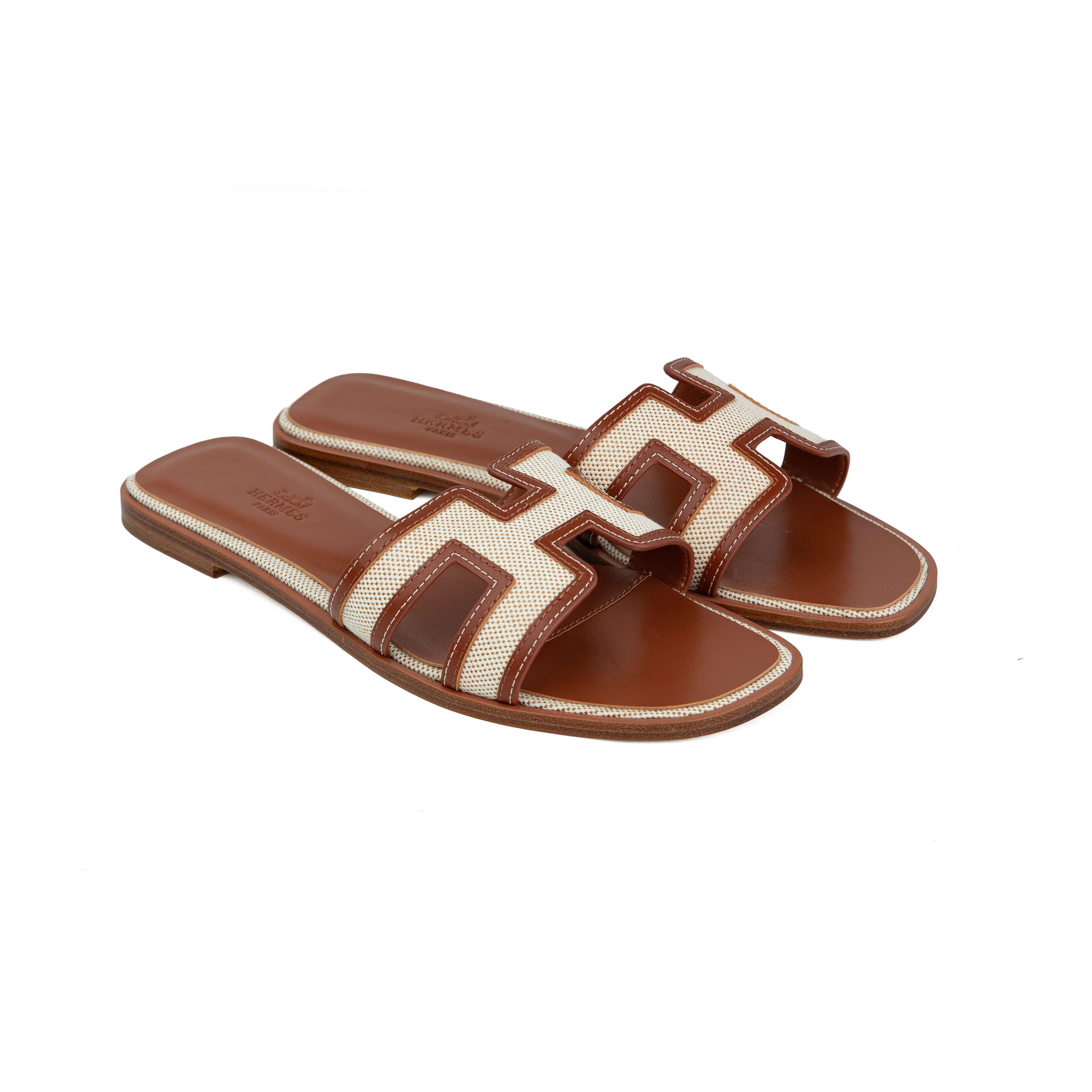 Shop the Hermès Oran sandals in écru canvas and gold Epsom leather.