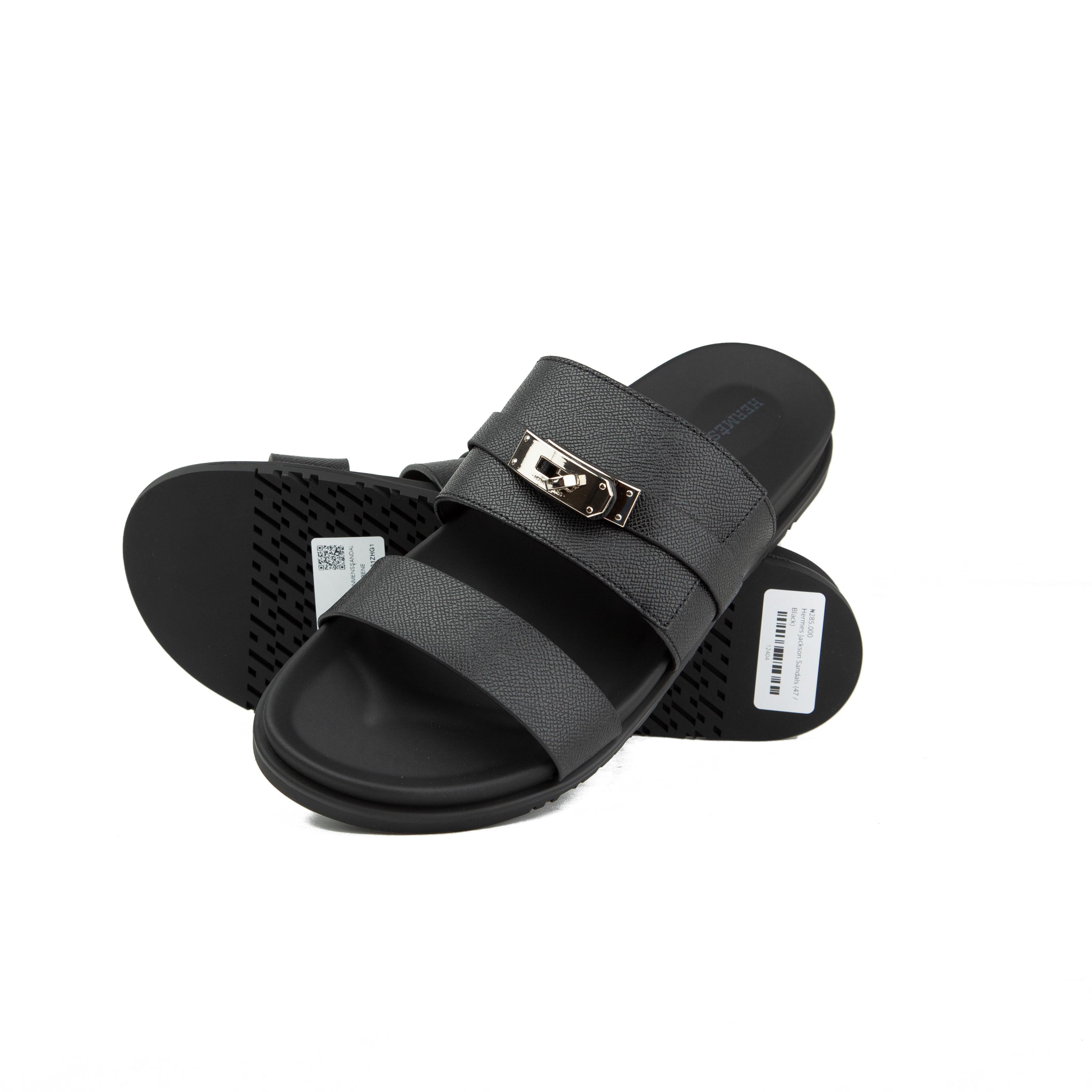 Black Hermès Chypre sandals in grained Epsom leather with silver Kelly buckle on a white background.