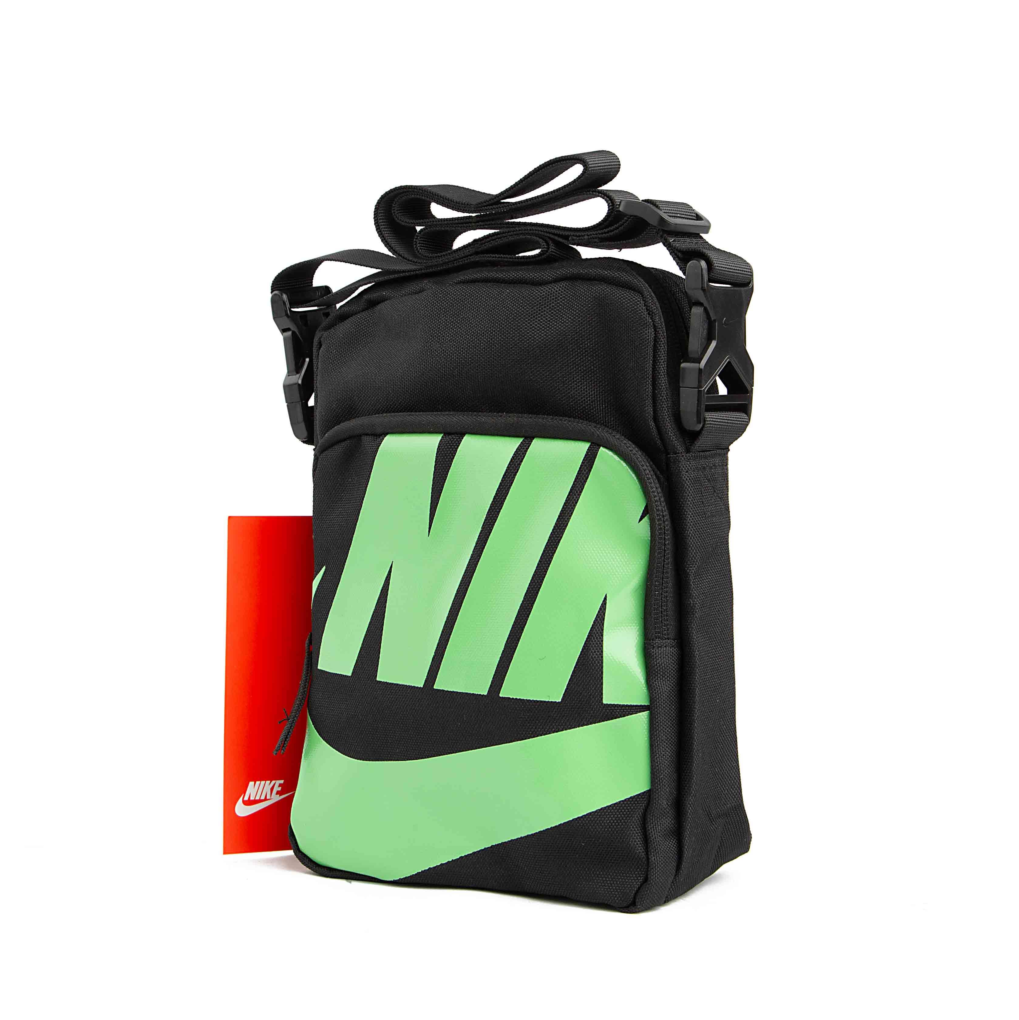 Black compact shoulder bag with adjustable strap and red product tag.