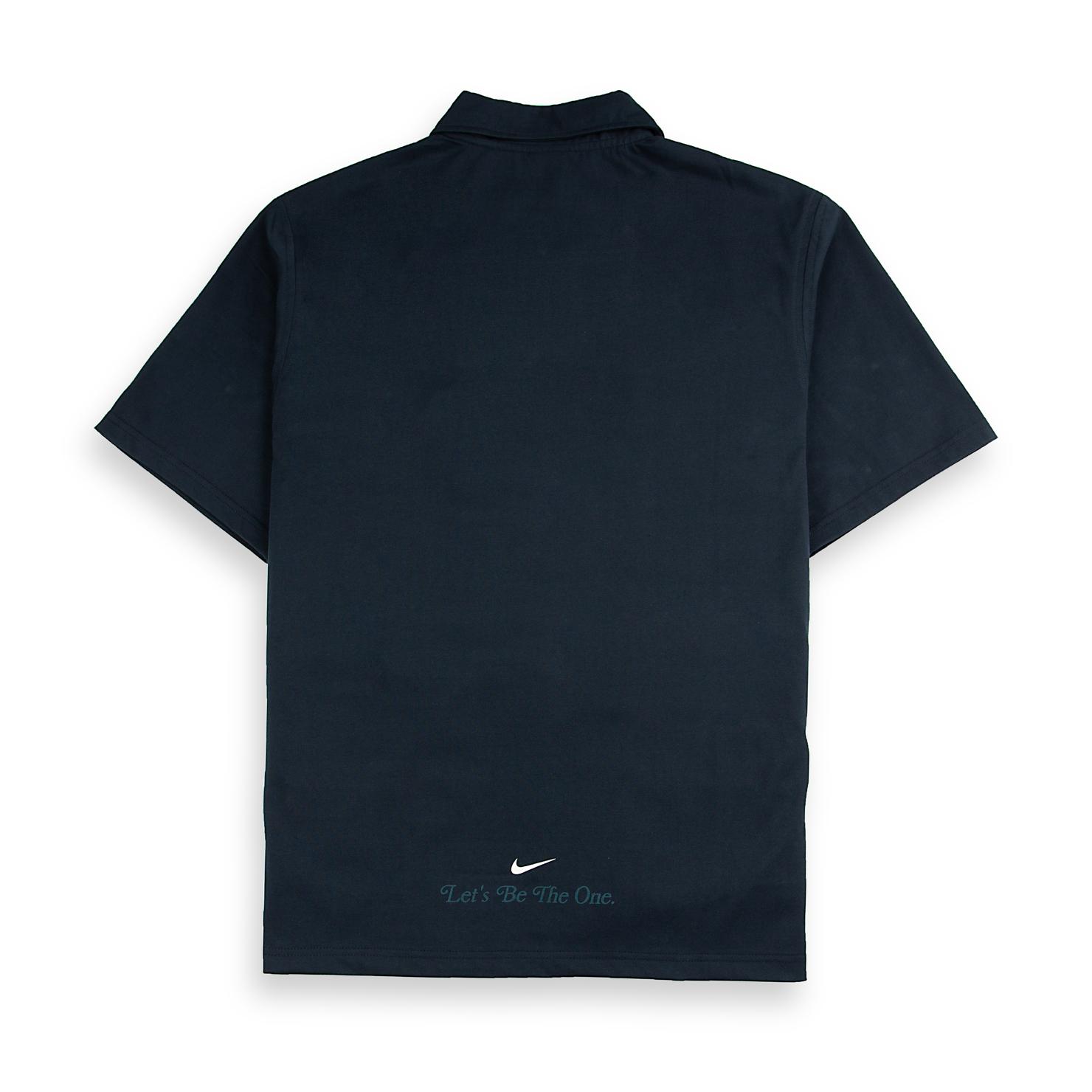 A Nike Men's vintage-style rugby polo shirt in navy with a teal stripe across the chest and a stylized embroidered Nike logo.