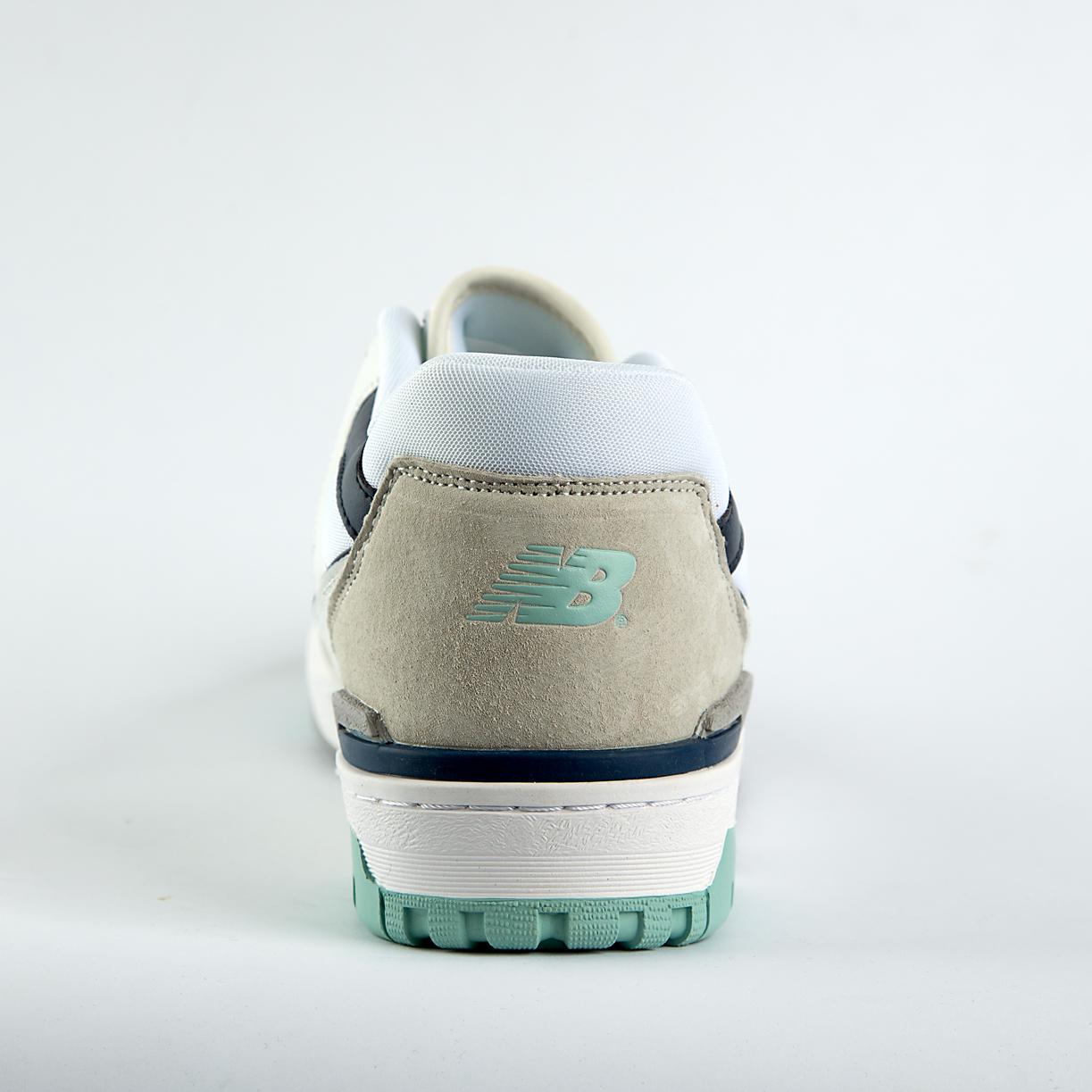 New Balance 550 sneakers in off-white with mint green, taupe, and gray accents. A retro low-top shoe for men and women.