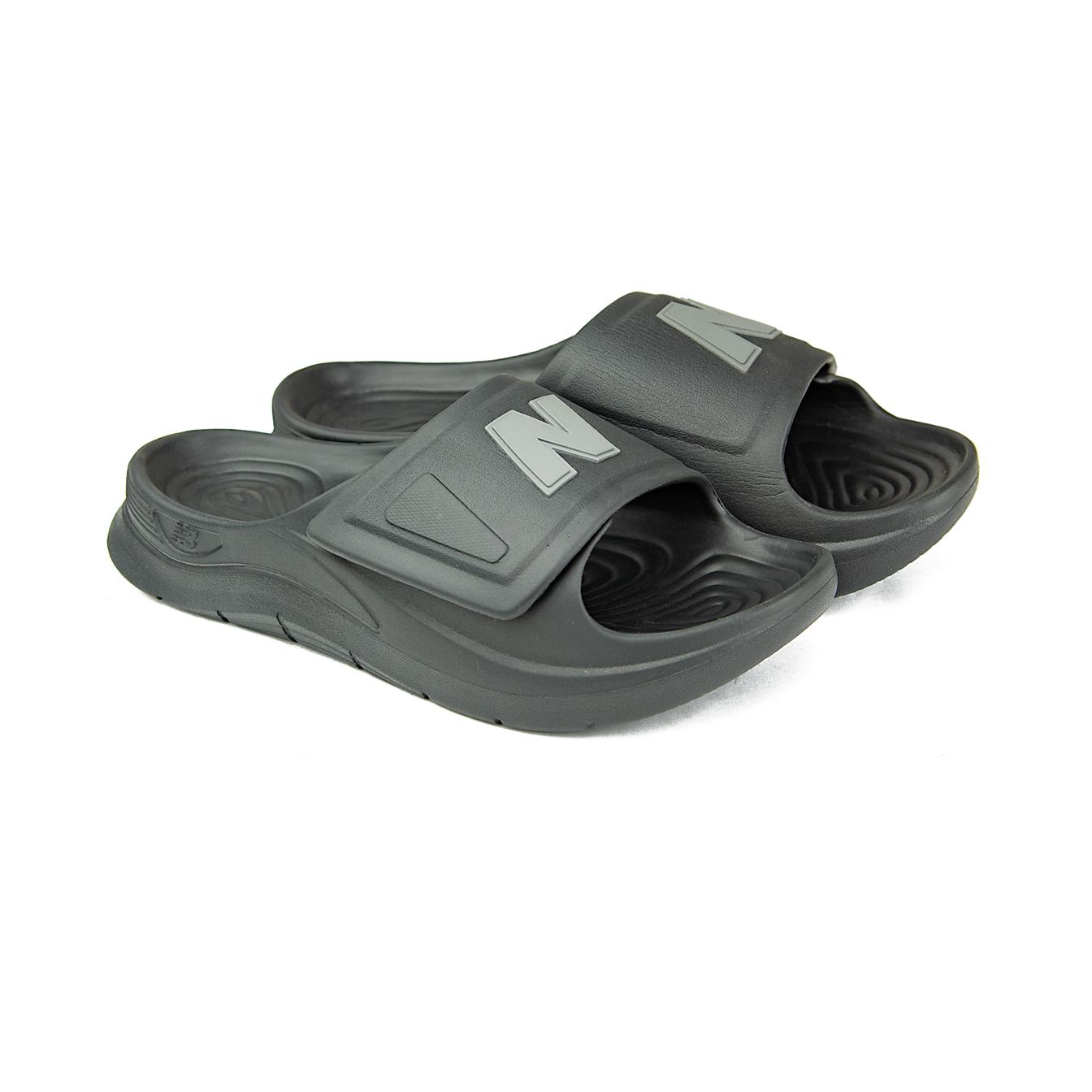 A pair of black New Balance 202XA adjustable slide sandals with a grey NB logo on the strap, shown against a white background.