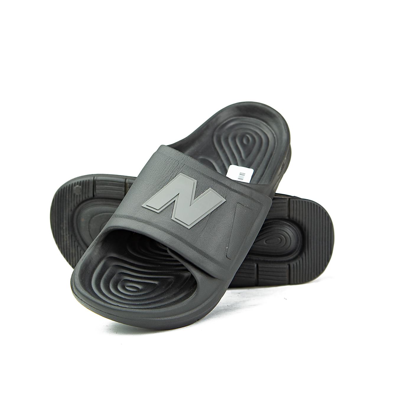 A pair of black New Balance 202XA adjustable slide sandals with a grey NB logo on the strap, shown against a white background.
