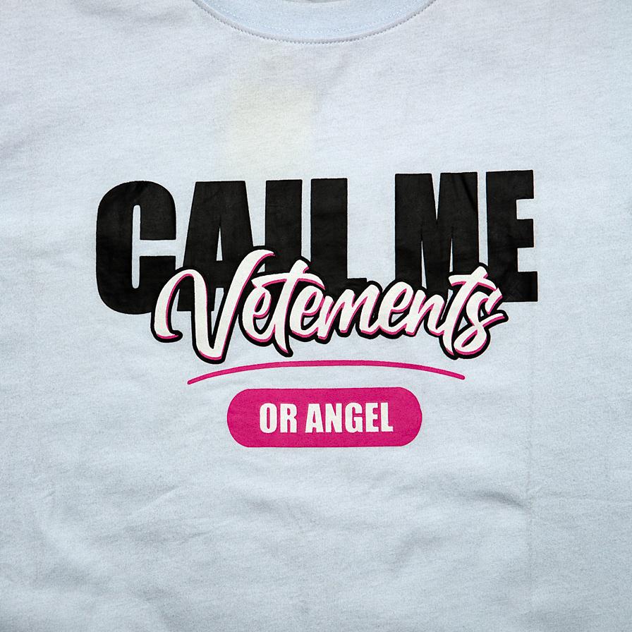 This is a white, short-sleeve crew-neck t-shirt featuring a bold, playful, and high-fashion inspired graphic slogan.