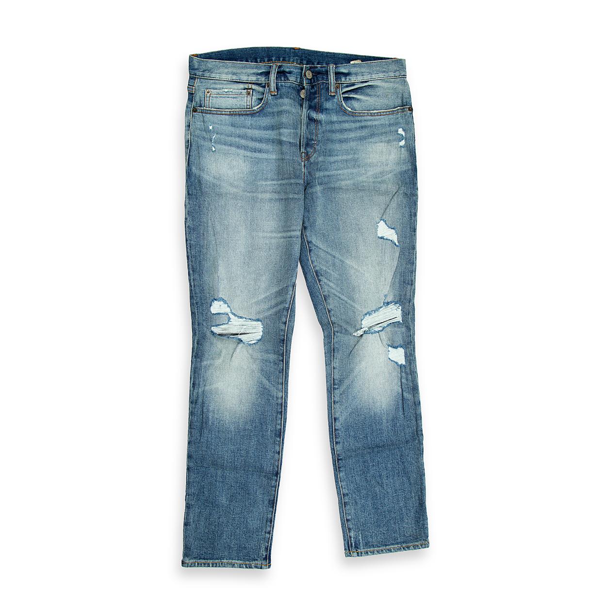 A bold, contemporary pair of men's jeans with a light-blue wash and heavy-duty distressing.