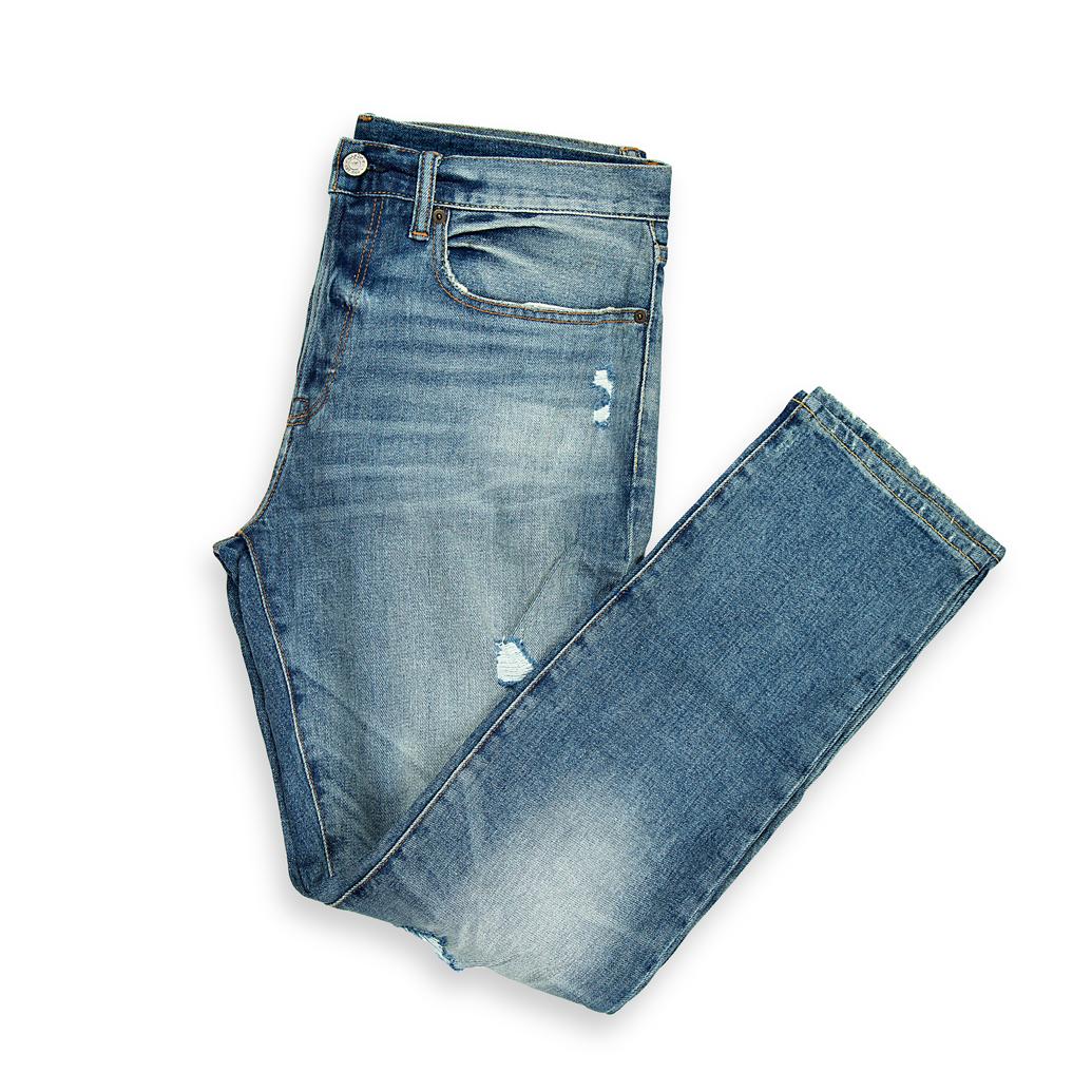 A bold, contemporary pair of men's jeans with a light-blue wash and heavy-duty distressing.