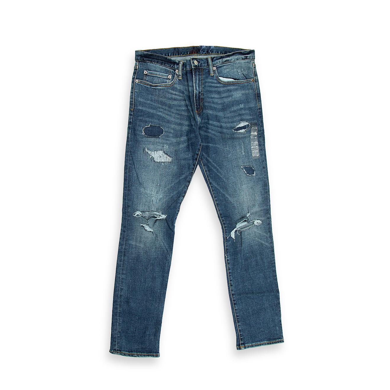 These are a pair of slim-tapered fit denim jeans in a deep, vintage-inspired indigo blue wash. The wash features significant fading and whiskering across the front, creating a naturally aged appearance.