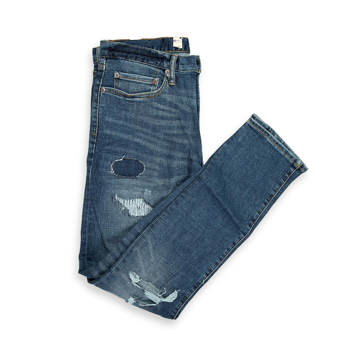 These are a pair of slim-tapered fit denim jeans in a deep, vintage-inspired indigo blue wash. The wash features significant fading and whiskering across the front, creating a naturally aged appearance.