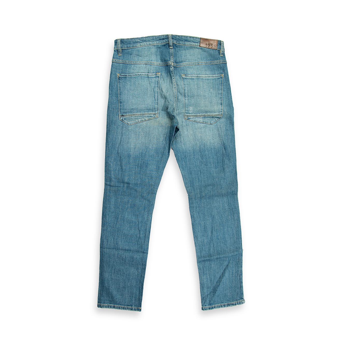 These are a pair of slim-fit jeans characterized by a light/medium blue acid wash (or heavily bleached wash), which gives the denim a highly faded, streaky appearance.