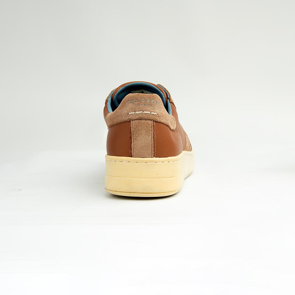 These versatile sneakers are crafted from a sophisticated mix of materials, featuring smooth brown leather panels complemented by textural suede accents in a matching tonal palette.