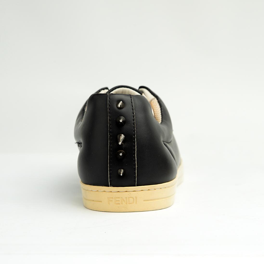 These sleek, premium leather sneakers perfectly blend classic low-top styling with the brand's signature playful-yet-edgy aesthetic.