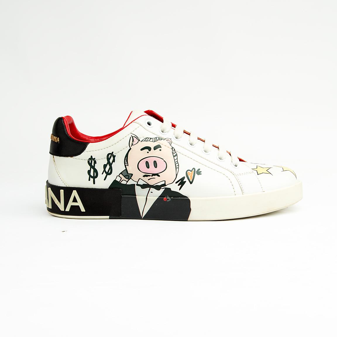 These pristine white leather sneakers are elevated by unique, vibrant hand-painted-style graphics, including the playful "Banker Pig" figure in a tuxedo, stylized money symbols, and bold star accents.