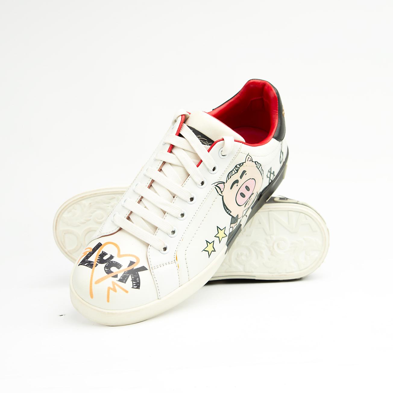 These pristine white leather sneakers are elevated by unique, vibrant hand-painted-style graphics, including the playful "Banker Pig" figure in a tuxedo, stylized money symbols, and bold star accents.