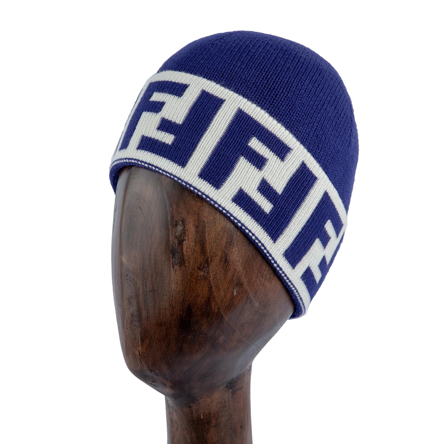 Blue knit beanie with white logo band, stylish winter hat.
