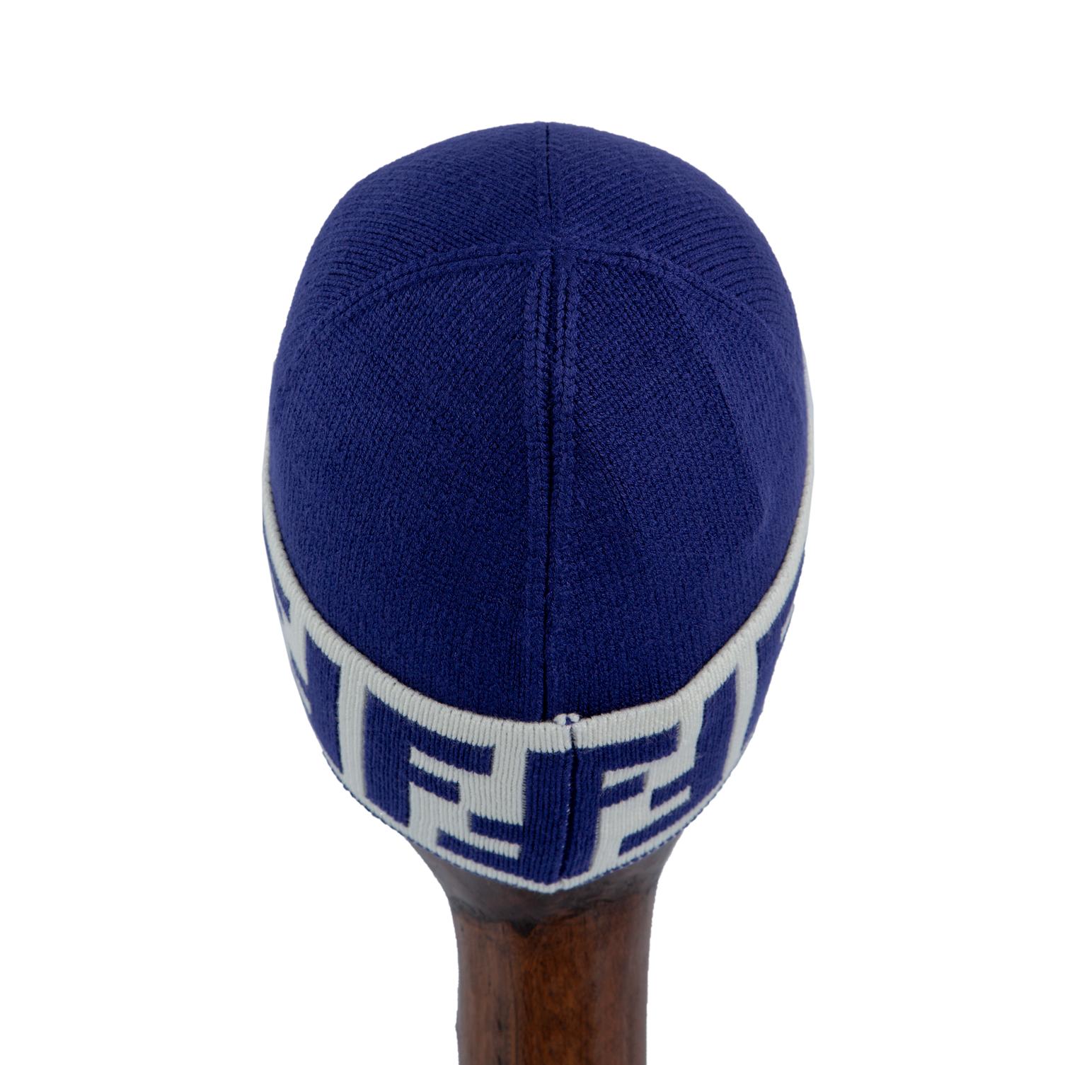 Blue knit beanie with white logo band, stylish winter hat.