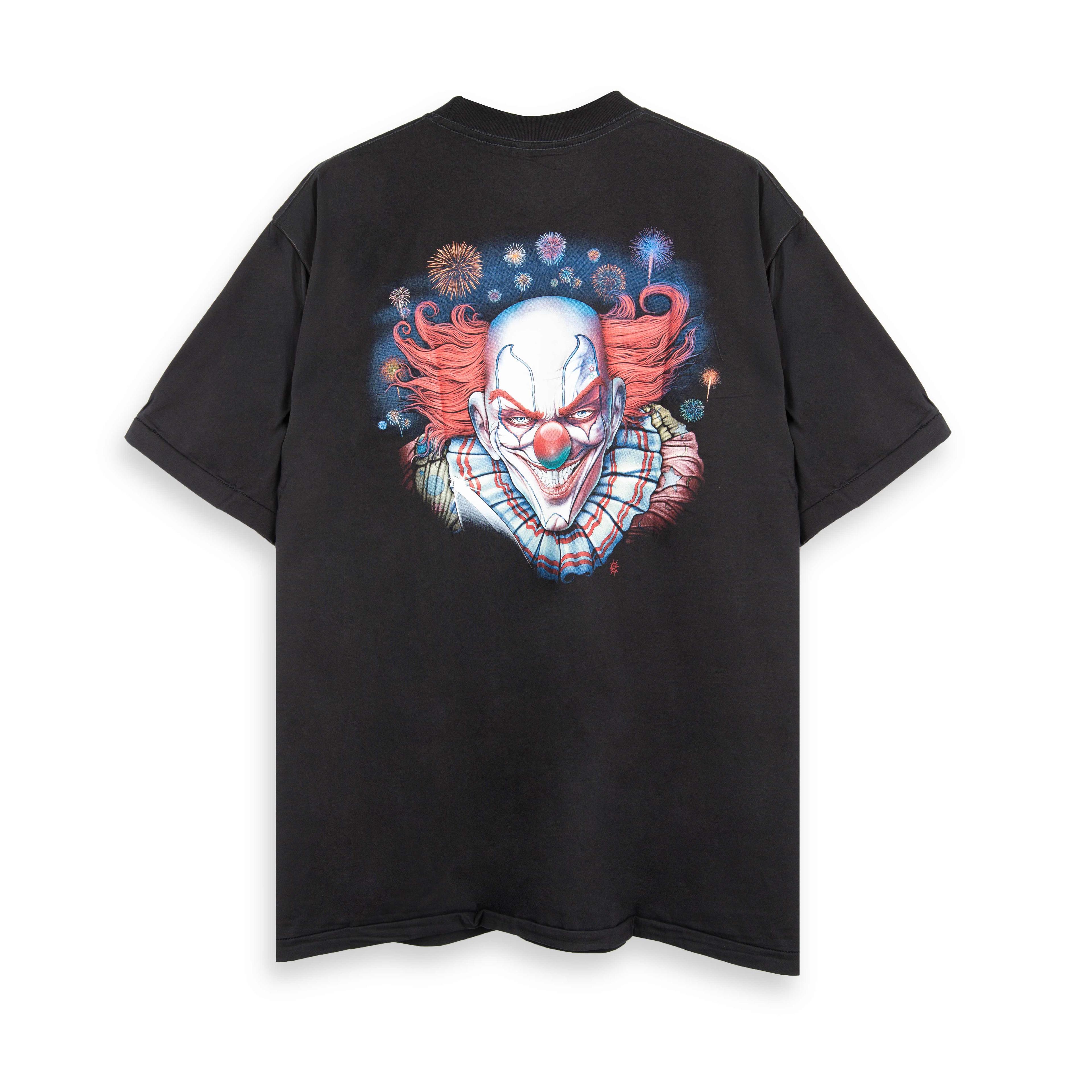 Rock Eagle black unisex t-shirt with a full-body graphic of a scary clown with red hair standing in a dilapidated, colorful carnival background.