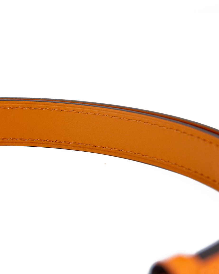 Men's orange skinny leather belt with gold interlock buckle.