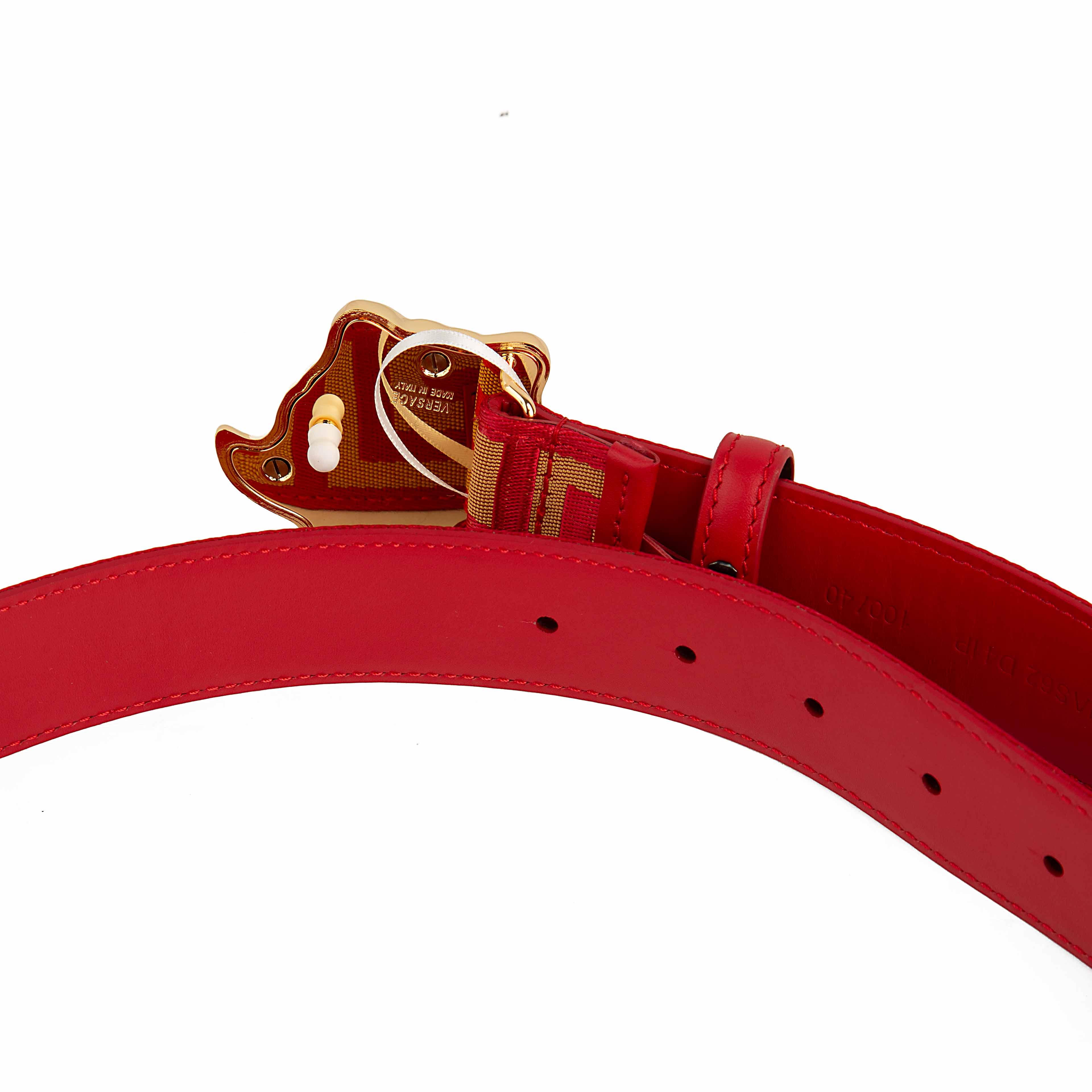 This belt is a masterclass in bold, unapologetic luxury. It features a vibrant scarlet red strap adorned with a continuous gold-tone Greca (Greek Key) motif, meticulously woven into a textured jacquard fabric.