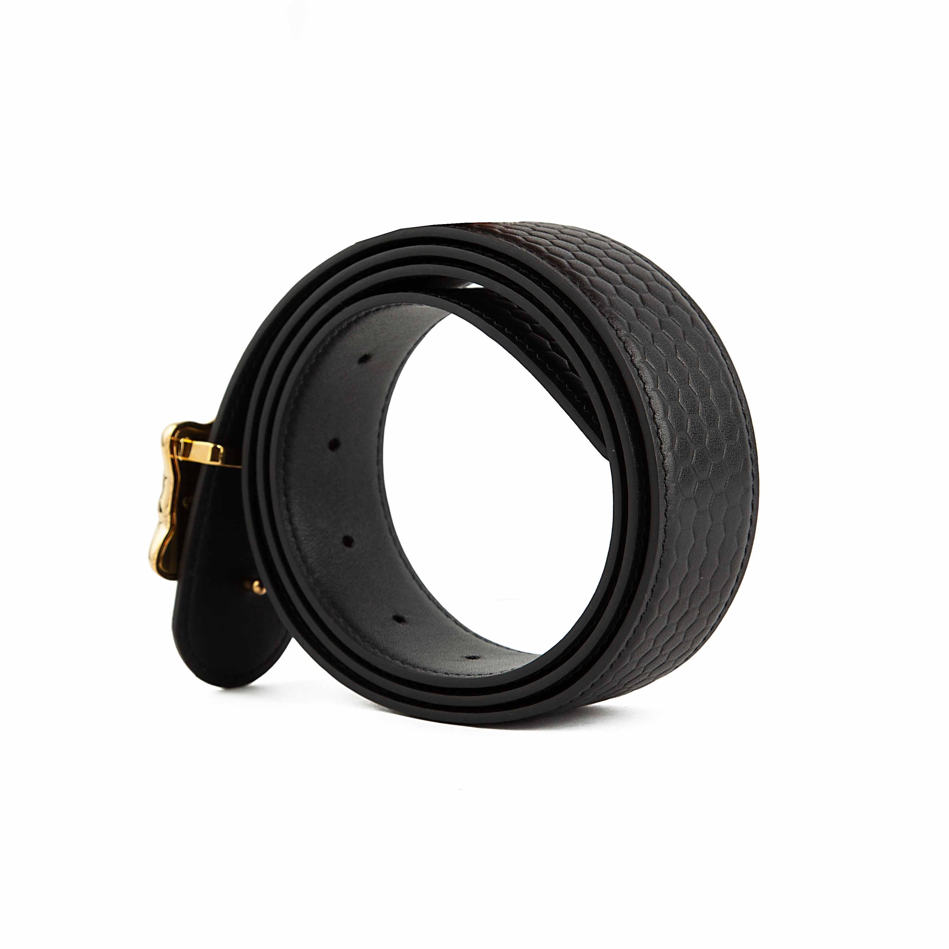 This statement accessory elevates the classic black leather belt through intricate detailing.