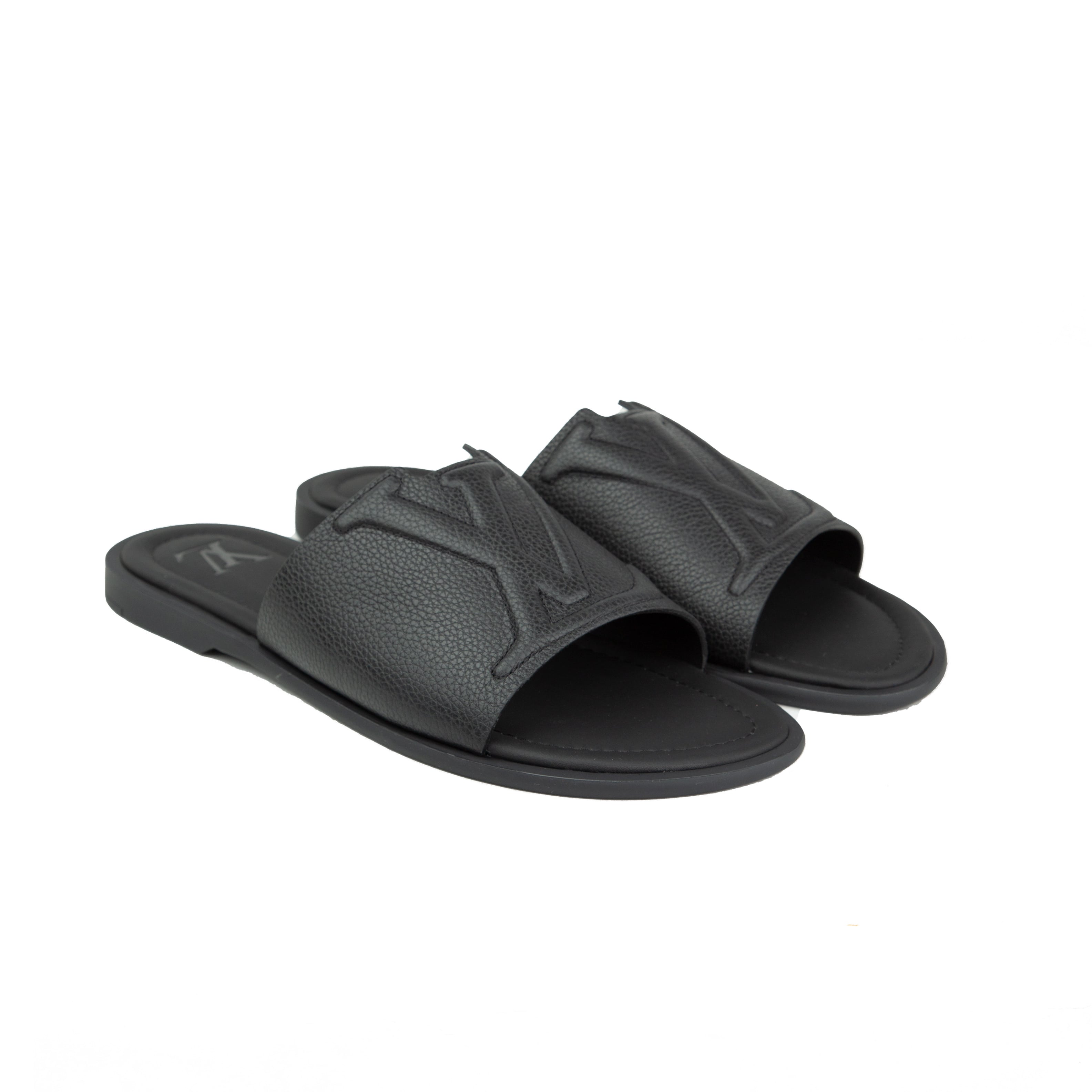 Shop the Louis Vuitton Waterfront Mule in black grained leather. Featuring an embossed LV logo and ergonomic sole for the ultimate luxury summer style.