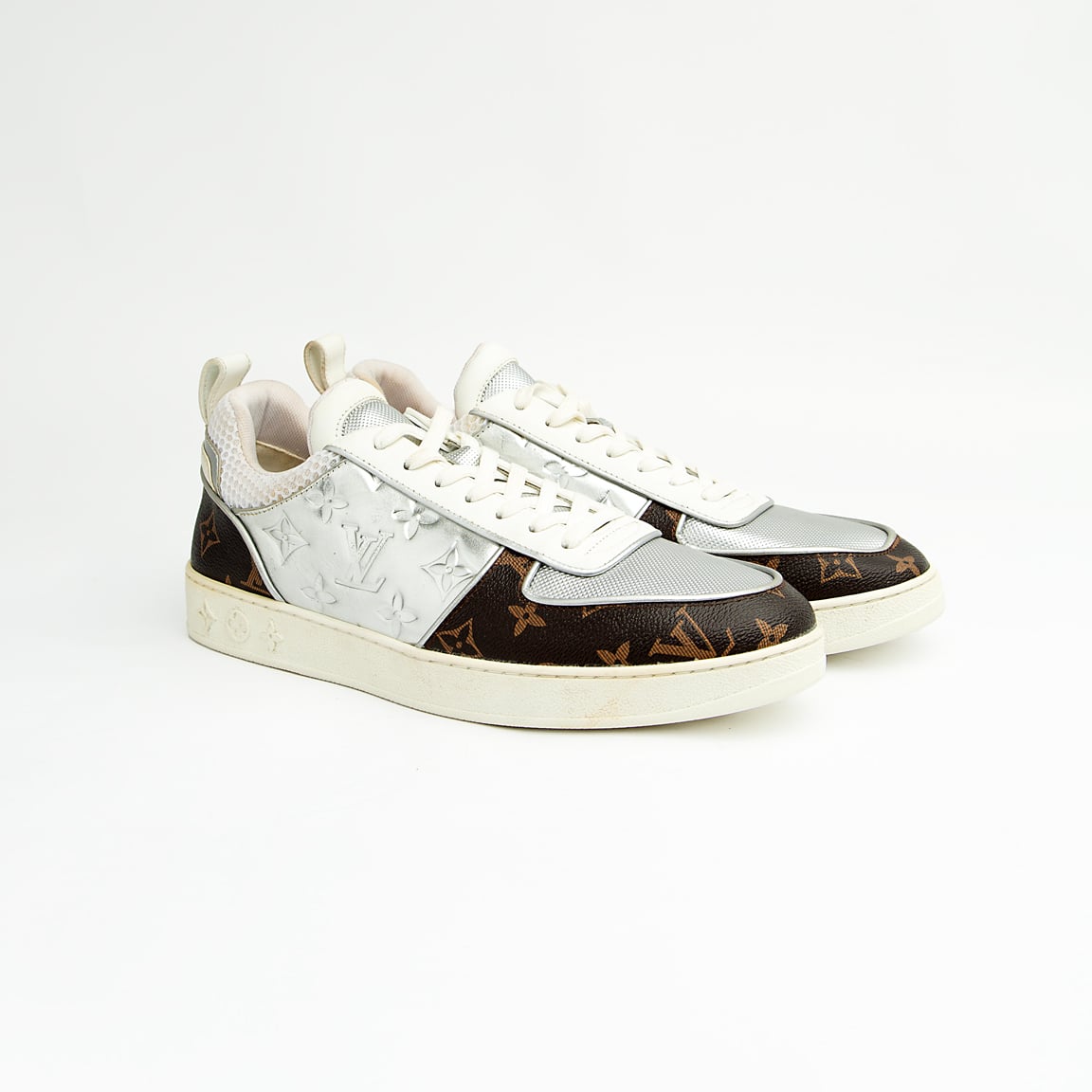 Dual-tone brown and silver unisex monogram embossed leather sneakers with classic design and comfortable sole.