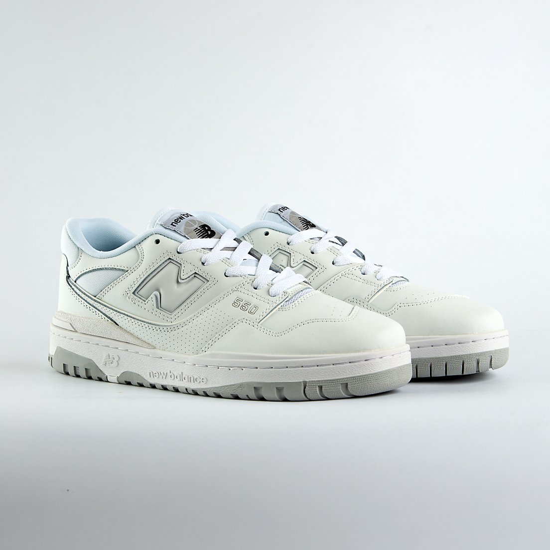 New Balance 550 sneakers in an off-white and light gray colorway. A classic low-top style with a minimalist look for men and women.