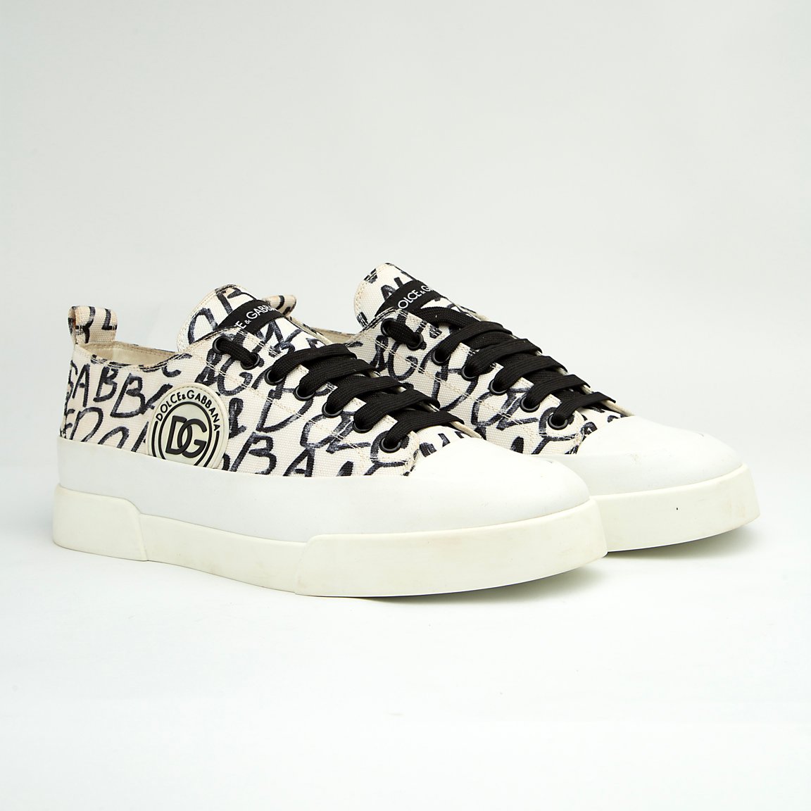 These are contemporary Dolce & Gabbana low-top sneakers featuring a classic tennis-shoe silhouette updated with bold, high-fashion branding. 