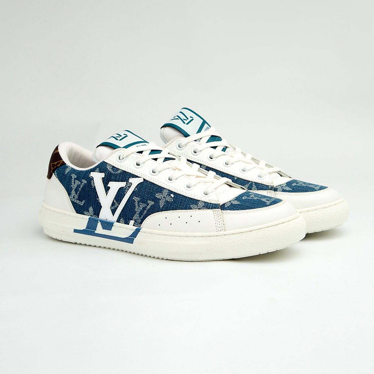 The Denim Riviera Ace is a high-fashion, low-top sneaker built on a classic court silhouette. It features a unique upper constructed from blue denim-style canvas or leather boldly printed with the recognizable Louis Vuitton Monogram pattern.
