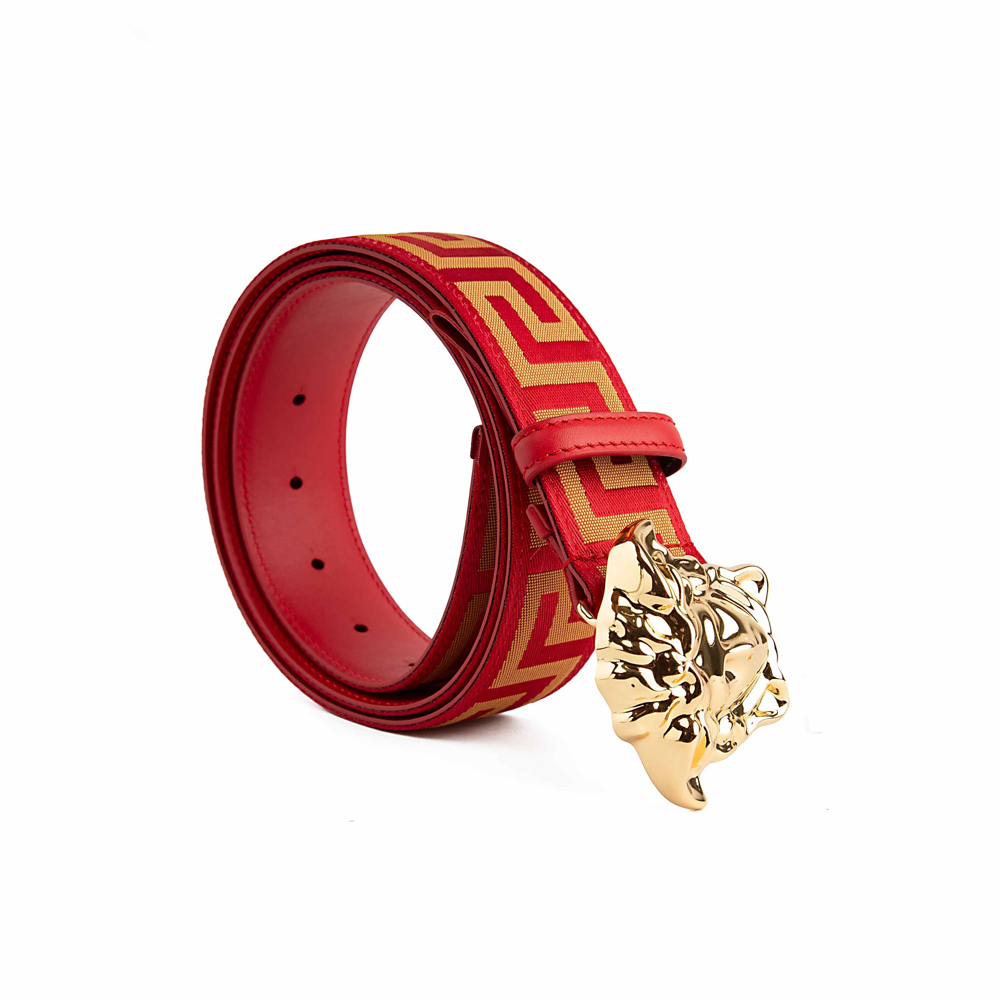 This belt is a masterclass in bold, unapologetic luxury. It features a vibrant scarlet red strap adorned with a continuous gold-tone Greca (Greek Key) motif, meticulously woven into a textured jacquard fabric.