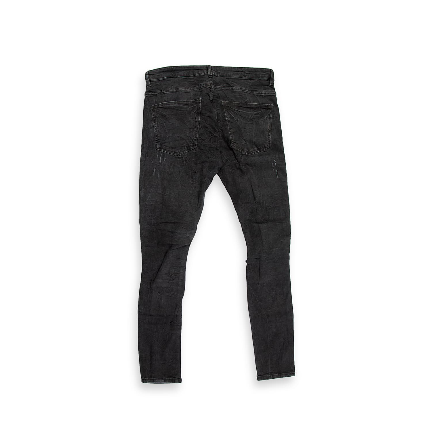 These are a pair of highly distressed skinny-fit jeans in a faded, washed black or charcoal colour.