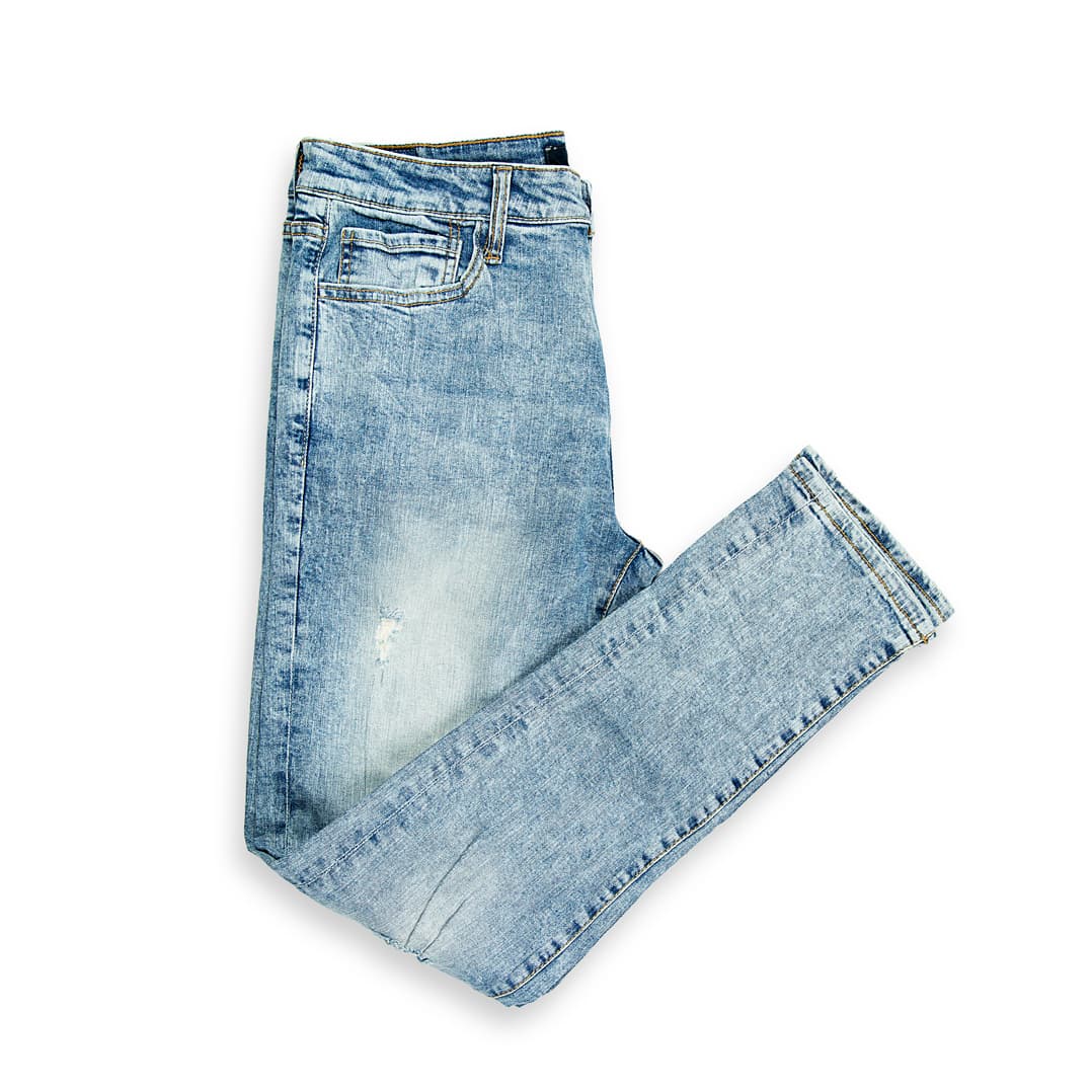These are a pair of skinny-fit jeans featuring a striking high-contrast acid wash (or mineral/snow wash). The wash results in a dramatic pattern of light blue/near-white spots and streaks against a medium blue denim base, giving them a retro, yet edgy aesthetic.