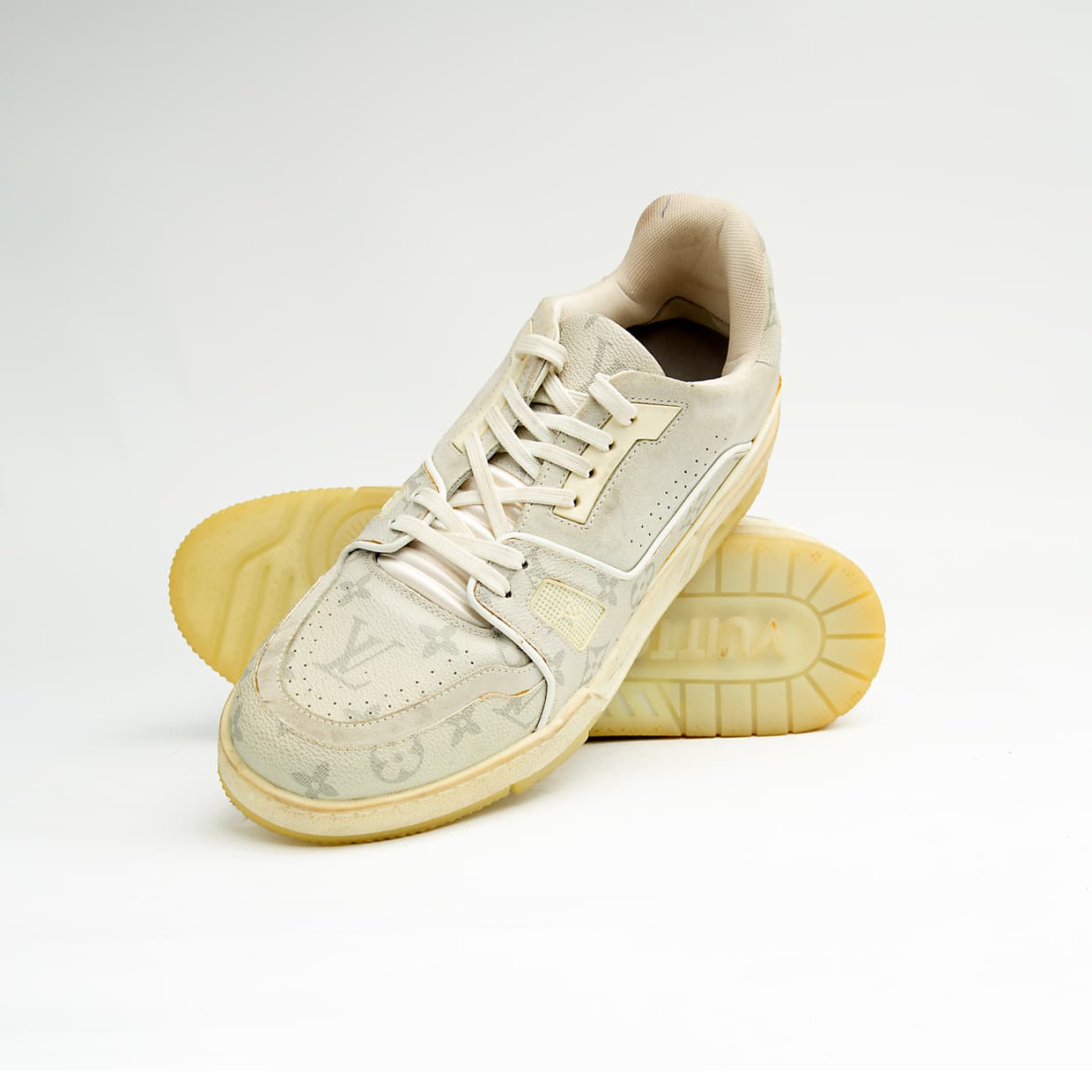 Cream monogram low-top unisex sneakers with retro sole and soft leather detailing.